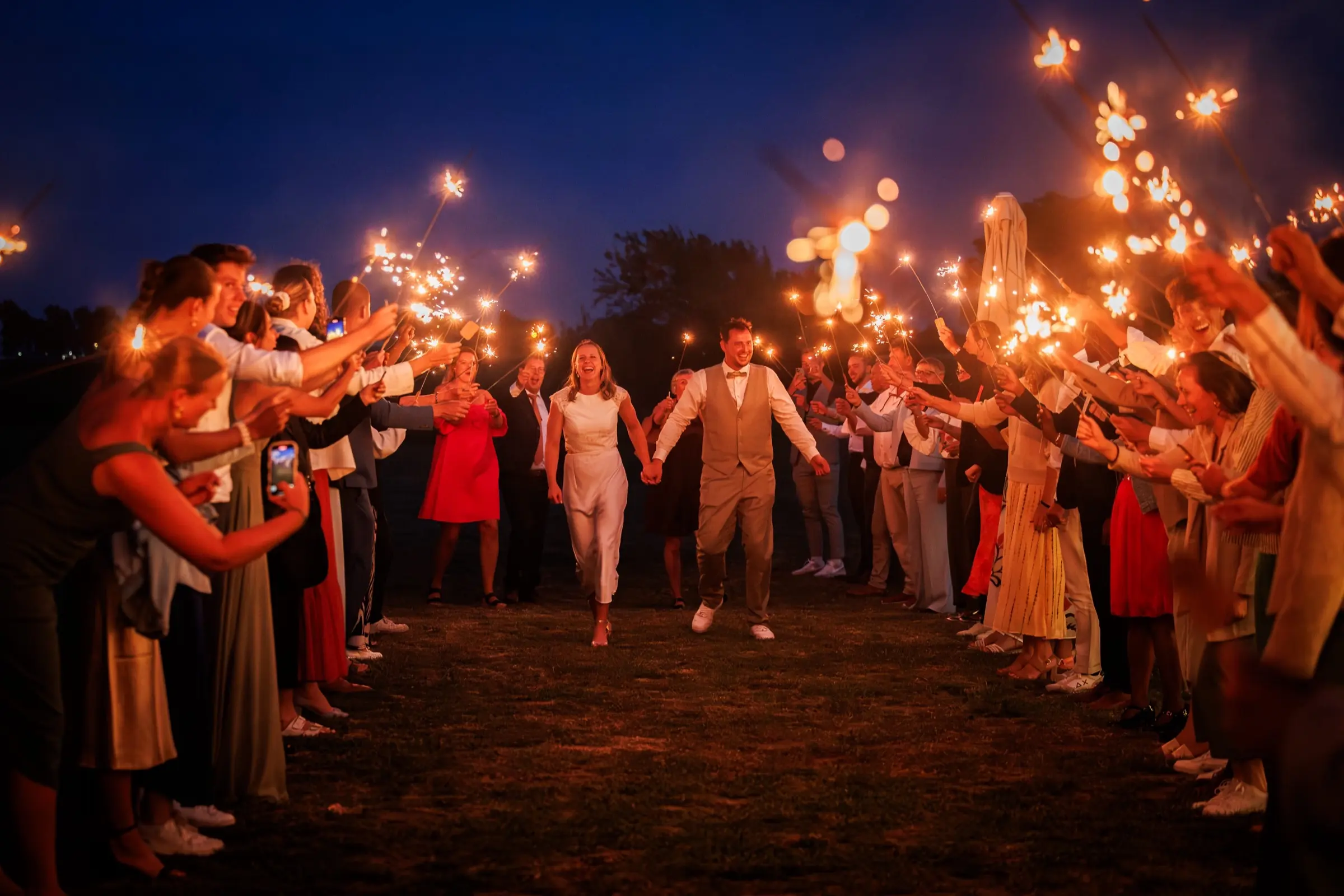 Romantisch bruidspaar tijdens sparkler exit bij avondbruiloft